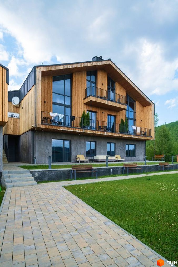 Апарт-готель Panorama Chalet – це чотириповерхова будівля з дерев'яним фасадом та великими вікнами, розташована на доглянутій території з газоном та доріжками.