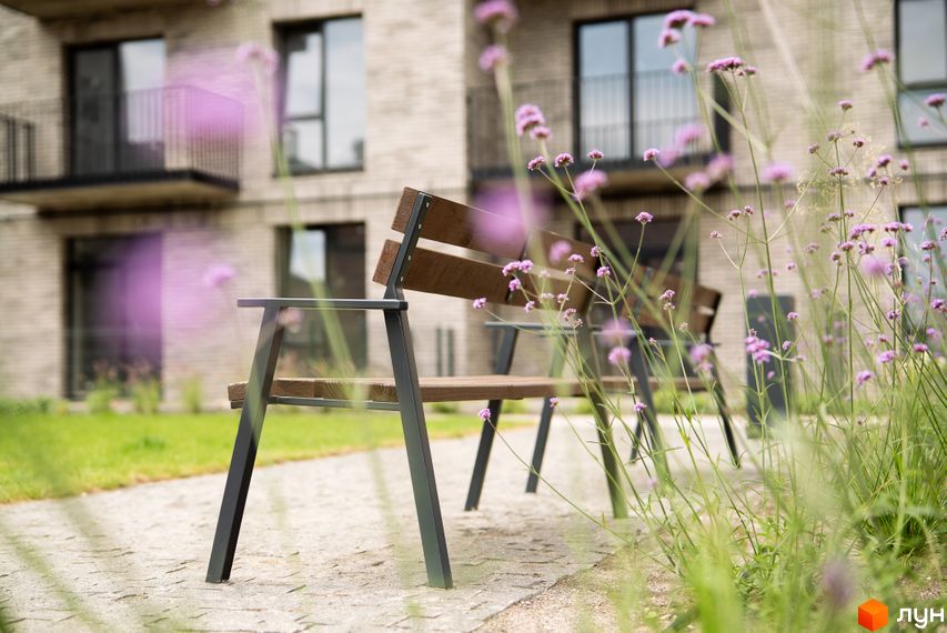 Новобудова ЖК WAWEL з лаконічним дизайном фасадів та зеленою прибудинковою територією з місцями для відпочинку.