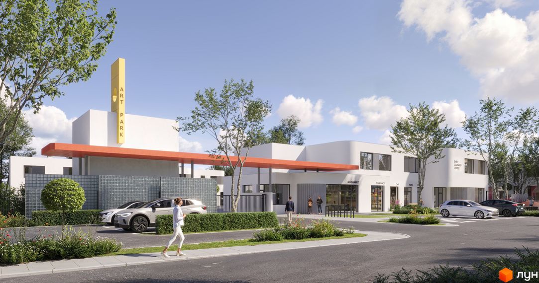 Комплекс ARTPARK з білими фасадами та оранжевим навісом, оточений деревами та парковкою з електромобілями.