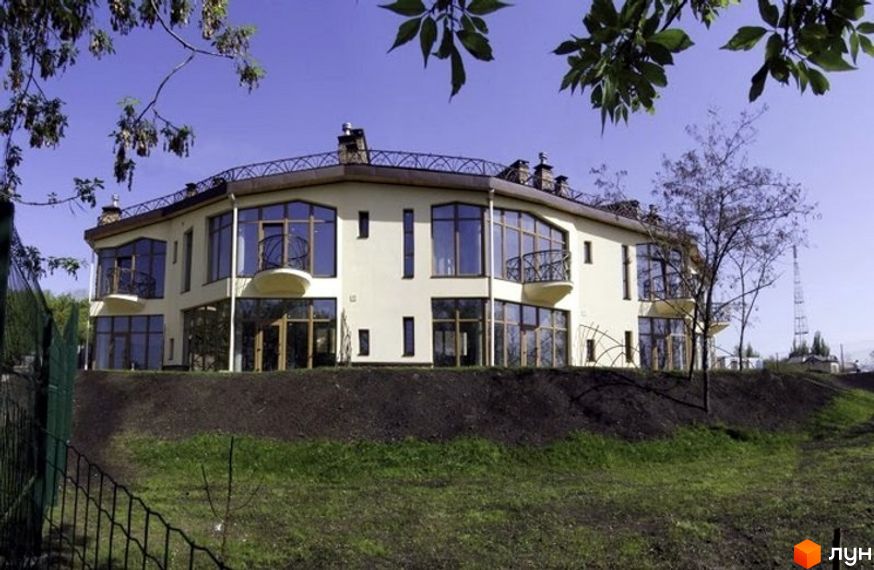 Таунхаус „Олегова Гора“ – двоповерхова новобудова світло-бежевого кольору з великими панорамними вікнами та балконами. Навколо будинку зелена галявина та огорожа.