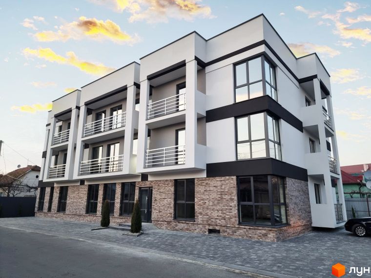 Зображення фасаду Житлового комплексу Преміум Хаус. Багатоповерхова будівля з балконами та великими вікнами, розташована на вулиці з тротуаром.