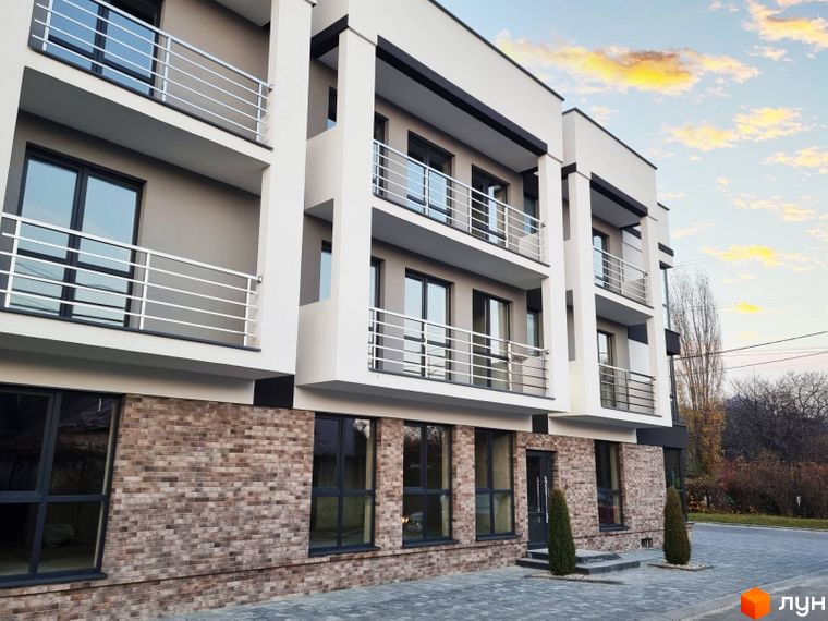 Зображення фасаду Житлового комплексу Преміум Хаус з балконами та панорамними вікнами. На передньому плані озеленена територія.