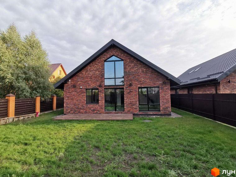 Котеджне містечко КМ Одноповерховий Київ - Дніпро. Фасад будинку з червоної цегли, великі вікна, тераса та зелений газон.