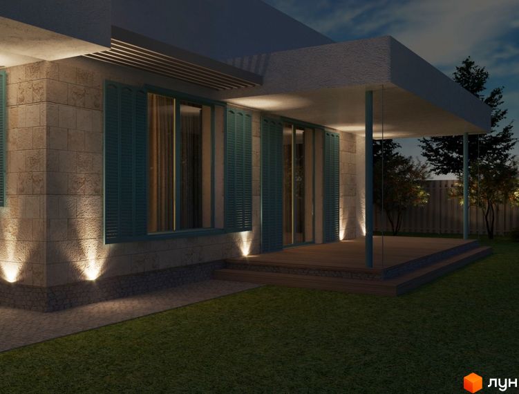 Котеджне містечко Чапаєвка: кам'яний будинок з бірюзовими віконницями та підсвічуванням фасаду, дерев'яна тераса та доглянутий газон.