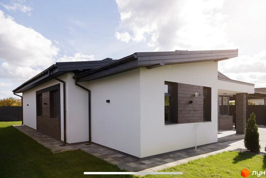 Зовнішній вигляд одноповерхового будинку з білими стінами та темним дахом на вулиці Мазепи. Прибудинкова територія з газоном та бруківкою.