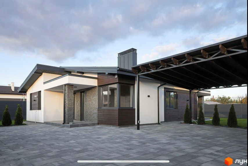 Сучасний одноповерховий будинок з навісом для автомобілів та бруківкою на прибудинковій території. Зовнішній вигляд новобудови на вулиці Мазепи.