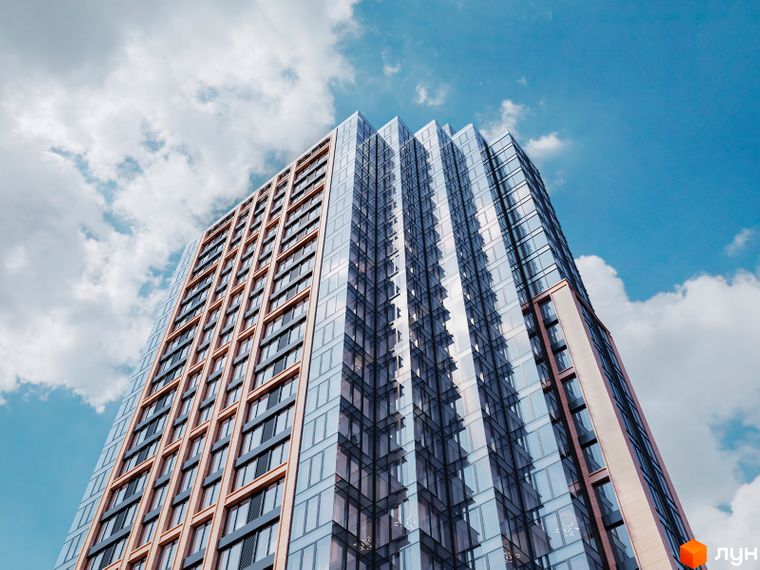Висотний житловий комплекс А136 Highlight Tower зі скляним фасадом та світлими панелями, що відбивають небо.