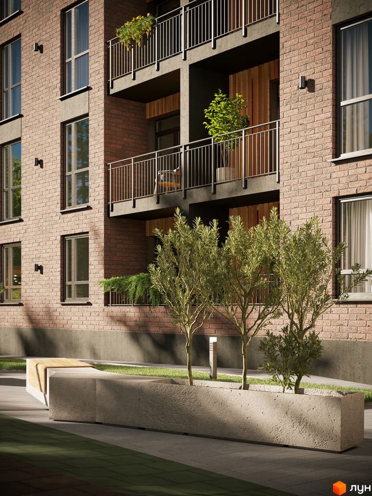 Зовнішній вигляд будівлі житлового комплексу SVOЇ PARKHOUSE з цегляними стінами, балконами та рослинами на прибудинковій території з лавкою та деревами.