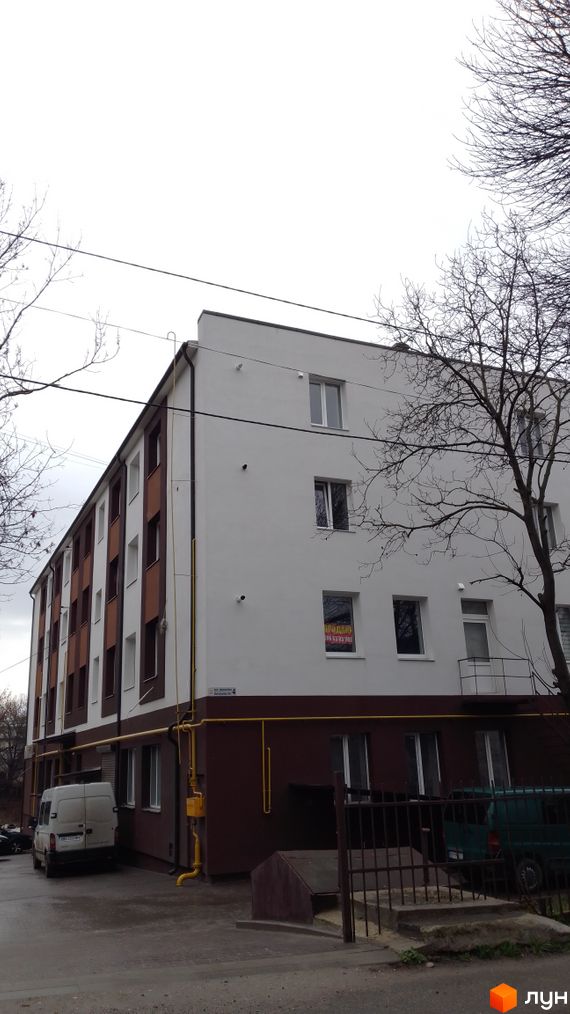 Зовнішній вигляд будинку ЖК по вул. Дорошенка, 4. На фото видно фасад будівлі з вікнами та прибудинкову територію.