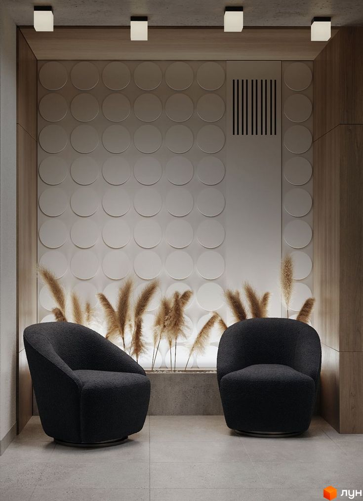 Інтер'єр холу в ЖК SVOЇ PARKHOUSE з двома кріслами, декоративними рослинами та стіною з круглими елементами.