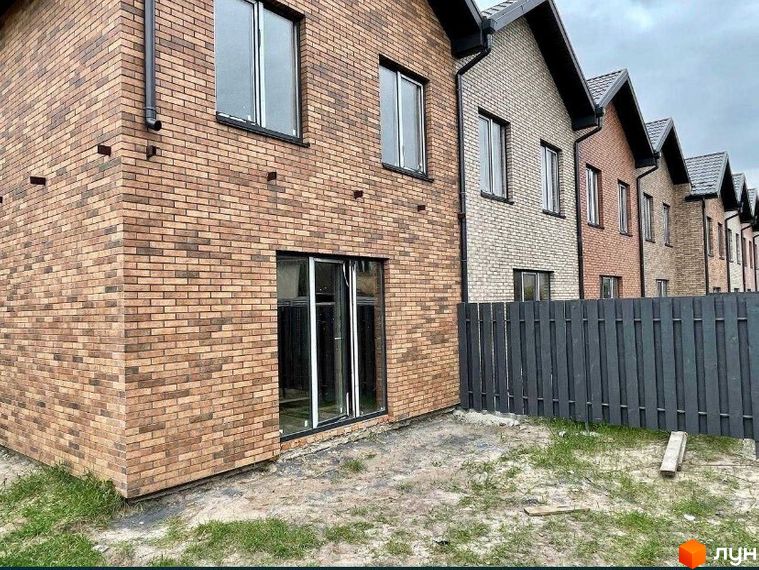 Таунхауси „Чемпіон“ з цегляним фасадом та прибудинковою територією з парканом. Зовнішній вигляд будинків та прибудинкової території.