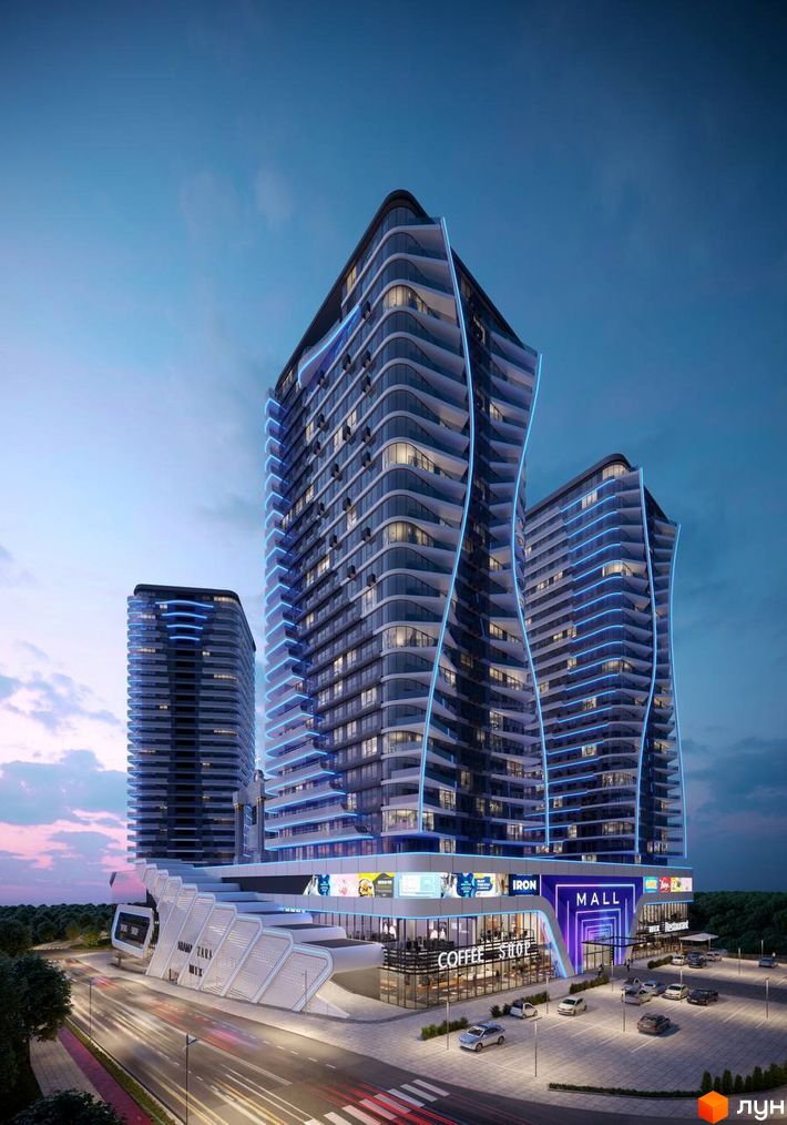 Житловий комплекс Aura city з футуристичною архітектурою та блакитною підсвіткою. Навколо комплексу розташовані торговельний центр, парковка та дорога з автомобілями.