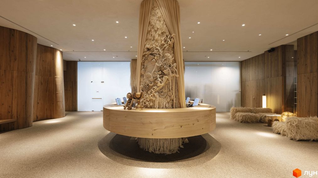 Інтер'єр апарт-комплексу Mountain Residence з дерев'яними елементами та арт-об'єктом у центрі. Затишна зона відпочинку з хутряними диванами.