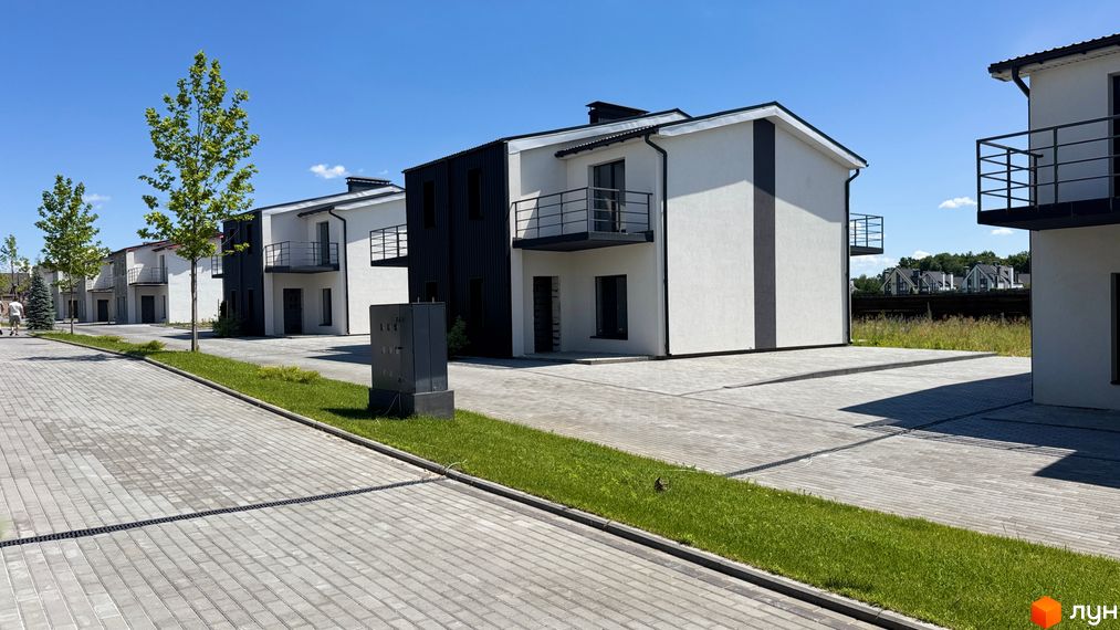 White-Blackie Duplex: двоповерхові будинки з чорними та білими фасадами, балконами та брукованою прибудинковою територією.