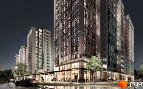 Нічна панорама житлового комплексу Феофанія City з високими будинками та освітленими вікнами. Біля комплексу розташовані автомобілі та пішохідні доріжки.